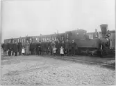 Uppställd personal vid persontåget med lok 4 och Co 8, Co 3 och CFo 20 på Råå station. Från vänster i bild banvakterna Carl Andersson och P. Magnusson, en okänd konduktör, konduktör Otto Pamp, stins Per Jönsson, fru Augusta Jönsson med dottern Ebba, lokförare Aron Andersson, eldare Pettersson, eldare Anders Lindahl, eldare Idof Christensson, putsare Sjöstedt, en okänd, konduktör Axel Kjellström, lokförare Sigfrid Göranssson, lokförare Oscar Jönsson, lokförare Magnus Nilsson med barnen Sigfrid och Sigrid, konduktör Göran Göransson, lokmästare Nils Rubin och lokförare F. Danielsson.
