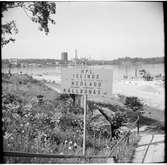 Informationsskylt som hänvisar till att hållplats Islinge är nedlagd, resande hänvisas till Källbonäs. Del av Hjorthagen på andra sidan av Lilla Värtan.