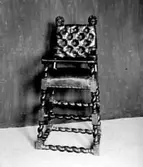 Skinnklädd barnstol med barnhuvud på ryggstödet.
I Västergötlands museums samlingar.