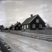 Arbetarbostäder i Strömsrum, bostadshus med sadeltak, träpanel och staket.