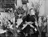 Kvinna omgiven av blommor firar 70-årsdag, Östhammar, Uppland