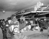 Brandkåren. Pojkar står vid och sitter i brandbil i Alingsås brandkårens garage på 1960-talet.