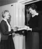 Förste postexpeditör Ingrid Hasselgren (i vanliga fall på
Författningsbyråns diarium) spelar rollen av öpx. Den tillfälliga
värdeteckensför-valtaren lämnar ut ett frimärks-förskott till
px-eleven Birgitta Nyman (utlånad från Mellersta Distriktet, ufpl).