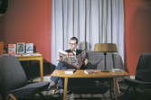 Bild 27 i en serie av 38. Läsrum med en person som läser
tidskriften Life. Som besökare agerar museets vaktmästare postiljon
Nils Svensson.