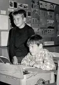 Två okända elever vid en skolbänk i Brattåsskolan cirka 1965.
