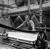 Man i arbete vid maskin på pappersbruket Papyrus i Mölndal, 6/5 1955.