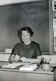 Ann-Marie Hillerström (1927 - 1997) sitter vid sin kateder i Kålleredskolan/Brattåsskolan okänt årtal. Hon arbetade som småskollärare i Kållered från 1962-.