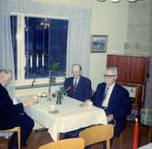 Tre män sitter vid ett uppdukat bord i matsalen på Brattåshemmet år 1968. Från vänster ses Alfred Mattsson (1895 - 1982), okänd man samt Johan Blomqvist (1887 - 1969).