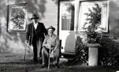 Två män utanför Brattåshemmet 1955 - 58. Till vänster står Alfred Johansson (1876 - 1964). Han arbetade som dräng på Högens gård. Till höger sitter Otto Emil Ottosson 