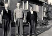Tre män står utanför Brattåshemmet i slutet av 1950-talet. 
Från vänster: Adolf Bengtsson, Backen (1881 - 1860), Otto Emil Ottosson 