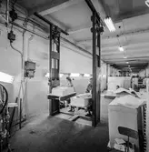 Kvinnor i arbete med att sortera papper på pappersbruket Papyrus i Mölndal, 12/4 1957. Lyftanordning.