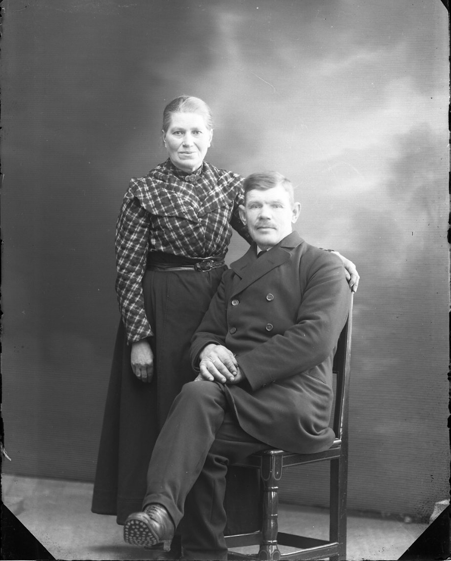 Calla Helena Sundbeck, Ett äldre par. En kvinna står intill en man som sitter på en stol.