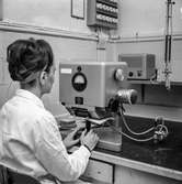 Kvinna i arbete vid tryckbarhetsmätare på pappersbruket Papyrus laboratorium i Mölndal, 30/8 1962.