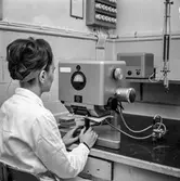 Kvinna i arbete vid tryckbarhetsmätare på pappersbruket Papyrus laboratorium i Mölndal, 30/8 1962.