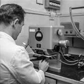 Man i arbete vid tryckbarhetsmätare på pappersbruket Papyrus laboratorium i Mölndal, 19/9 1962.
