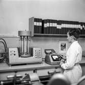 Kvinna i arbete vid dimensionsstabilitetsmätare på pappersbruket Papyrus laboratorium i Mölndal, 30/8 1962.
