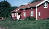 Några personer står utanför Hembygdsgården Långåker 1:3 1980-tal.