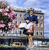 Kvinna med pojke i famnen fotograferade vid Stadshusplatsen i Mölndal, 17/9 1968.