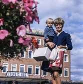 Kvinna med pojke i famnen fotograferade vid Stadshusplatsen i Mölndal, 17/9 1968.