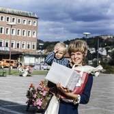 Kvinna med pojke i famnen fotograferade vid Stadshusplatsen i Mölndal, 17/9 1968.