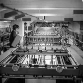 Kvinna i arbete vid maskin på pappersbruket Papyrus i Mölndal 1/10 1969.