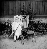 ETT BARN VID EN BARNVAGN.