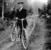 EN MAN MED SIN CYKEL PÅ EN SKOGSSTIG.