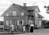 HANDLARE P.J. JANSSON MED FAMILJ.
SÖNERNA BERTIL OCH ELMER OCH HUSTRUN KRISTINA,
PÅ GÅRDSPLANEN FRAMFÖR LANTHANDELN.