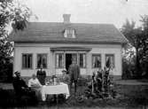 Två kvinnor och tre män vid kaffebordet i trädgården.
Enligt uppgift är det August och Augusta samt Maria och Karl.