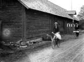 TVÅ KVINNOR PÅ CYCKEL PASSERAR EN LADA.