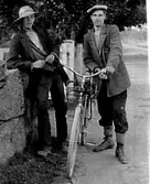 TVÅ MÄN STÅR VID EN CYKEL.