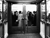 Bild tagen inifrån Samköps livsmedelsbutik på öppningsdagen 1962. Utanför dörrarna står kunder och väntar på att få släppas in.