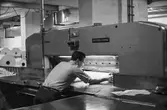 Man i arbete vid skärmaskin på pappersbruket Papyrus i Mölndal, hösten 1970. Renskärning av papper för att få exakta mått. Anställda på Papyrus kallade skärmaskinen 