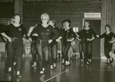 Kållereds Gymnastikförenings damer har uppvisning i Ekenskolans gymnastiksal år 1986.
Första paret från vänster: Amy Högström och Eivor Bjerrhede (ledare).
Andra paret från vänster: Kerstin Axelsson (skymd) och Britta Olsson.
Tredje paret från vänster: Inger Pettersson och Lisbet Kårlin.
Fjärde paret från vänster: Ansy Simonsson och Berit Rossing.
Femte från vänster: Majrid Kvick.