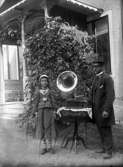 En flicka och en man med grammofon vid prästgårdens veranda, Lillhärad.