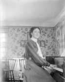 Kvinna vid piano.