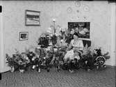 Kvinna i bostadsmiljö omgiven av blommor firar 50 år, Östhammar, Uppland