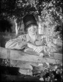 Kvinna i hatt vid staket, Östhammar, Uppland