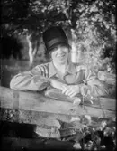 Kvinna i hatt vid staket, Östhammar, Uppland