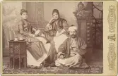 John och Antonie Rettig, sittande i en fotostudio iklädda orientaliska kläder. I mitten sitter Antonies syster Sophie-Louise von Plessen.