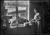 Gerda Thörn matar hästen med äpplen genom köksfönstret