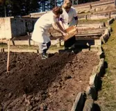 Potatis- och grönsaksodlingar på baksidan av Brattåshemmet, våren 1979. Från vänster: Okänd kvinna samt föreståndare Aina Ekstedt. Relaterat motiv: A1856.