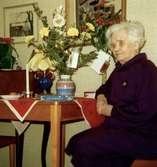 Ellen (Elin) Gustavsson uppvaktas på 90-årsdagen på Brattåshemmet 1979-12-30. Har arbetat med stryk/tvätt vid Kålleredshemmet i Torrekulla. Född 30/12 1889 i Katarina Församling, Stockholm. Död 25/10 1989 i Fässberg, Mölndal. Bodde på Brattåshemet tills det lades ner 1986. Hon var döpt Elin men kallade sig för Ellen.