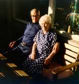 Skräddaren Per Pettersson (1896 - 1981) och sömmerskan Agnes Ekstedt (1898 - 1984) sitter på en parkbänk utanför Brattåshemmet våren 1979.