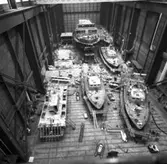 Bevakningsfartyg, Spica III, vedettbåtar och SAM
Översiktsvbild av fartygsbyggen i skrovhallen, bevakningsfartyg, Spica III, vedettbåtar och SAM.\\\\anm. neg ingår i en serie om 5 bilder varav endast den första V 91623 scannats/gp