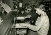 Biblioteksassistent Ingrid Hansson hjälper barnen att hitta/söka i bok-kartoteket på Kållereds bibliotek 1980-tal.