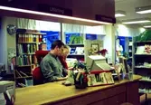 Okänd man samt bibliotekschef Ingalill Ekwall vid expeditionsdisken på Kållereds bibliotek 1990-tal.