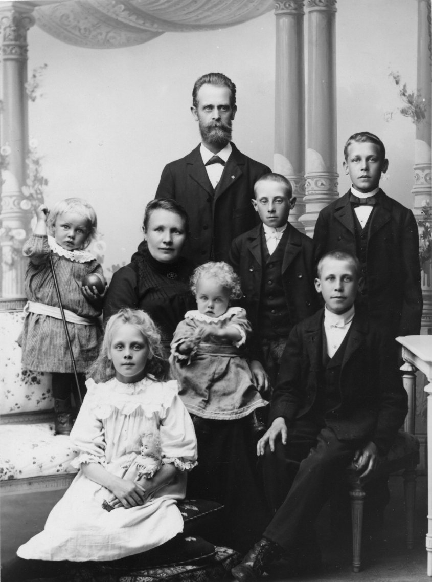 Calla Helena Sundbeck, Gruppbild med familjen Johan Alfred Johansson, stående. Hustrun Johanna Johansdotter sitter på en stol framför mannen med ett litet barn i knät. Pojken som sitter på en stol till höger heter Hugo