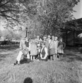 Gruppbild. Två kvinnor och barn iklädda folkdräkt. Skansen.