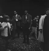 Klädd pedagog bland besökare i Skansens stadskvarter.